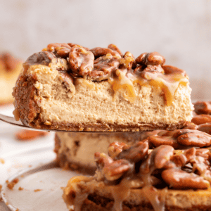 Vista laterale di una fetta di cheesecake alle noci pecan sollevata dal resto della cheesecake