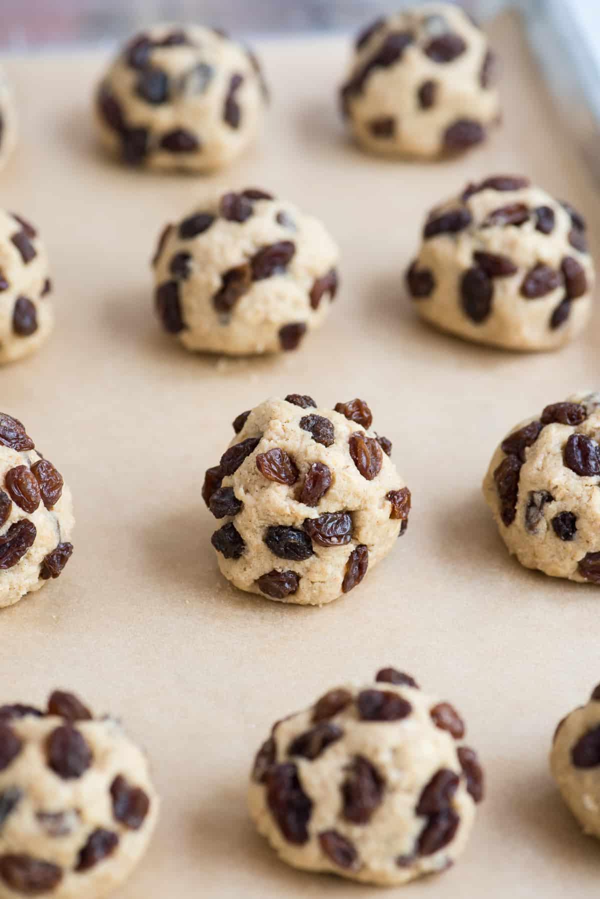 Palline di impasto per biscotti avena e uvetta su carta forno marrone