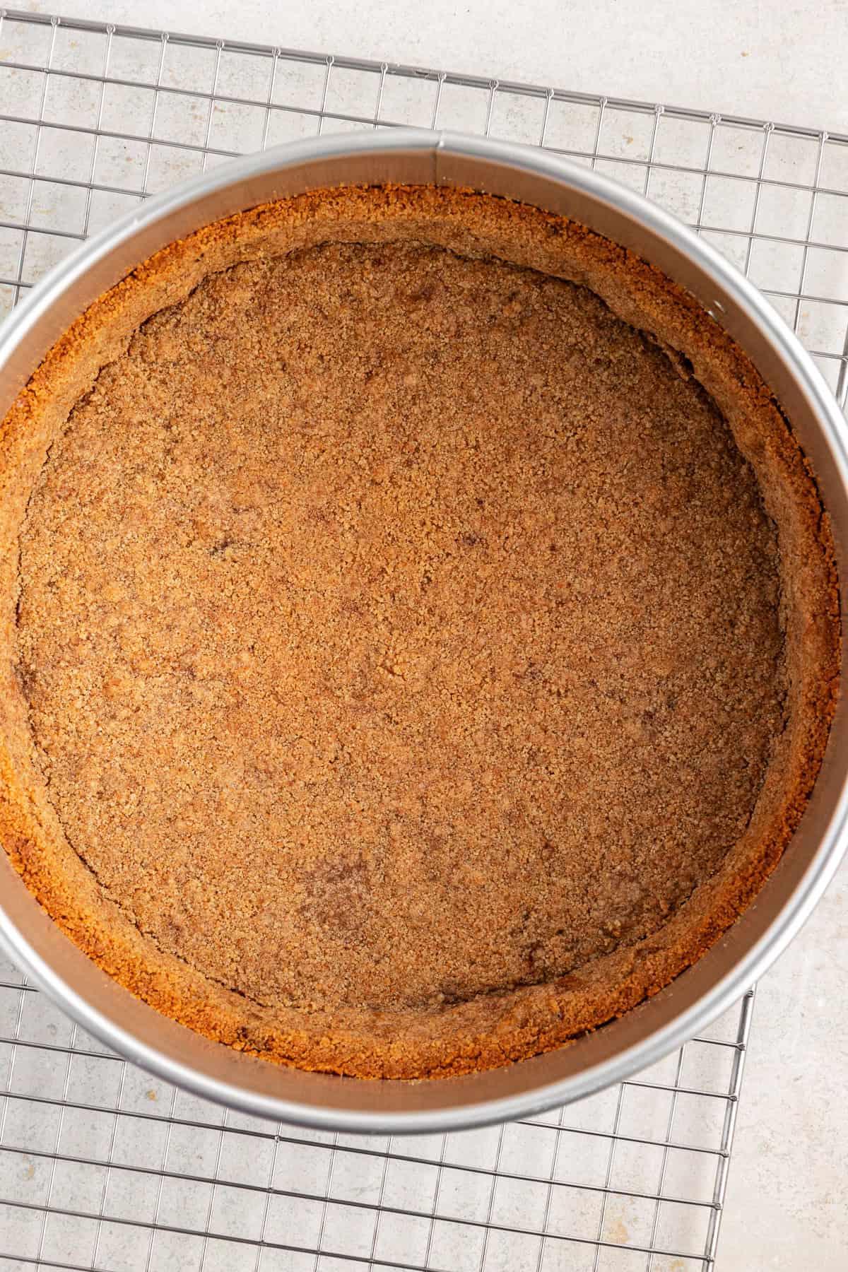 Base di biscotti graham in una tortiera a cerniera sopra una griglia