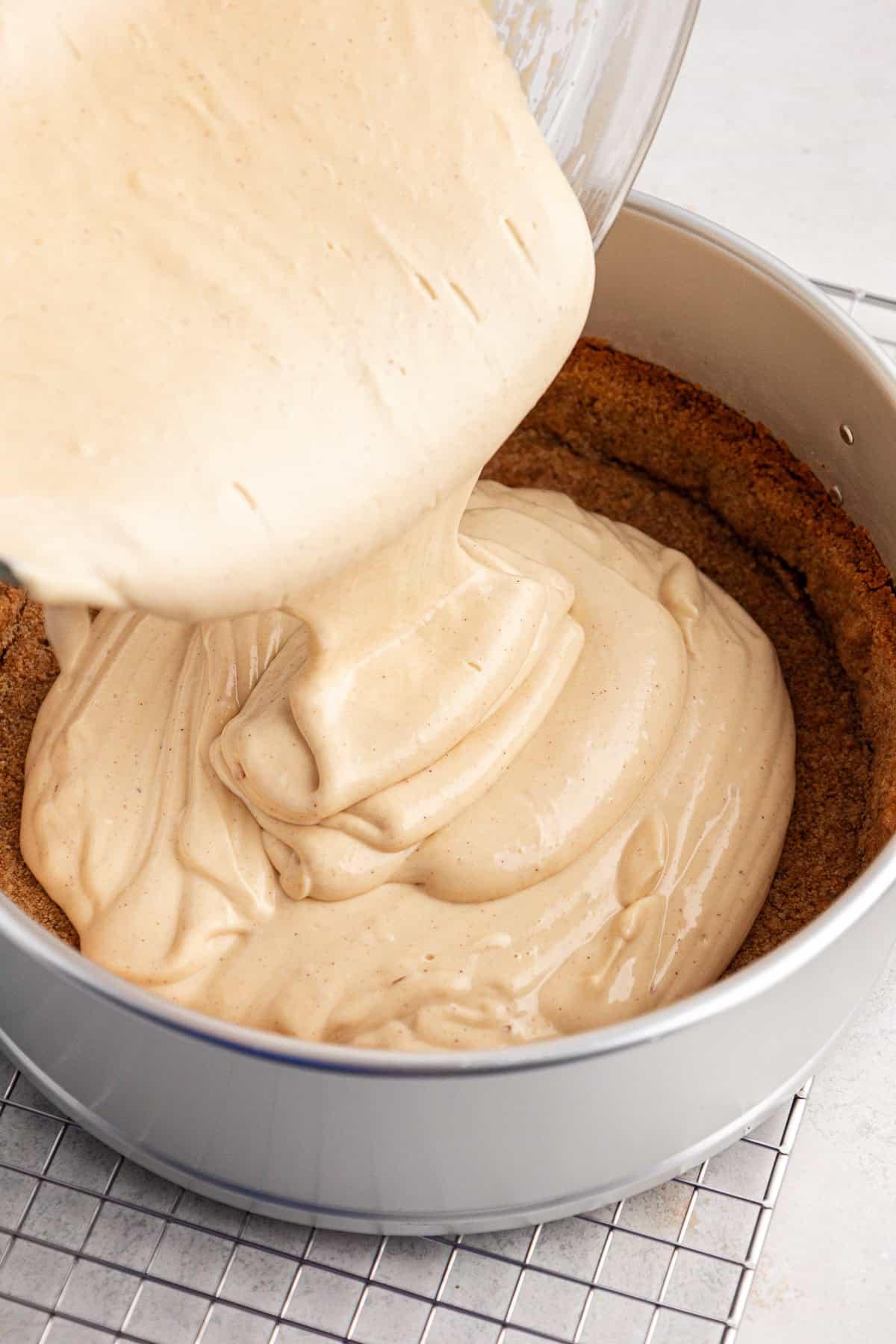 Impasto della cheesecake versato in una tortiera a cerniera con la base di biscotti graham