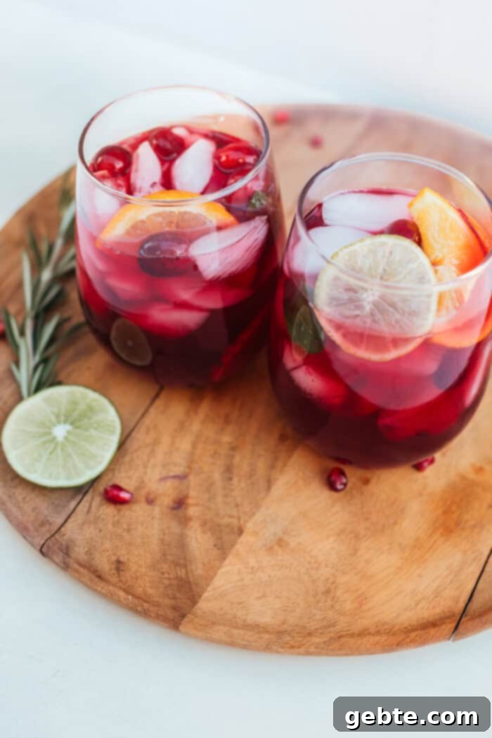 Mocktail με ρόδι, φέτες πορτοκαλιού και δυόσμο, ιδανικό για γιορτές.