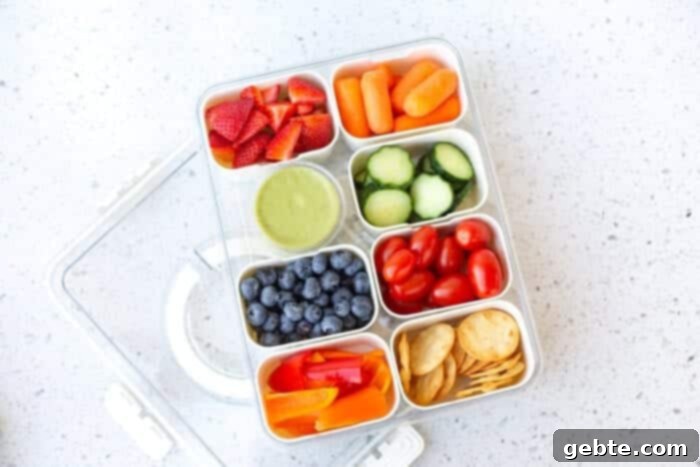 Ανοιξιάτικη Σνακοθήκη 4 Snackle Box γεμάτο με πολύχρωμα φρούτα όπως φράουλες, σταφύλια και μύρτιλα.