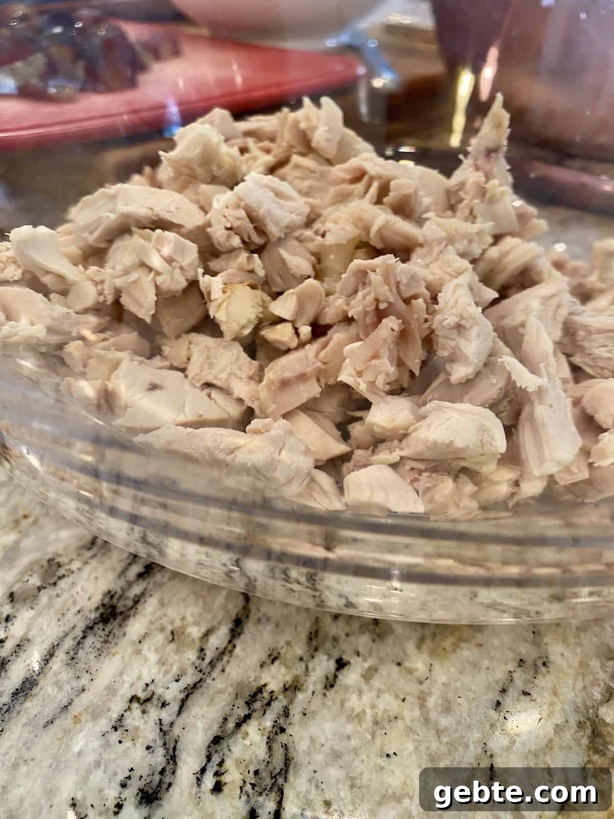 Diced and shredded cooked chicken in a bowl.