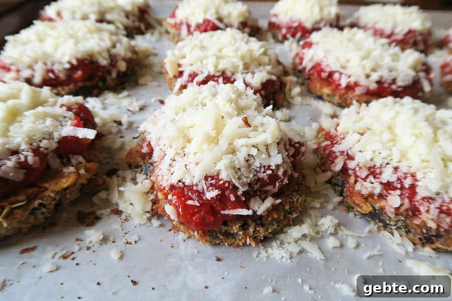 crispy eggplant parmesan being topped with cheese