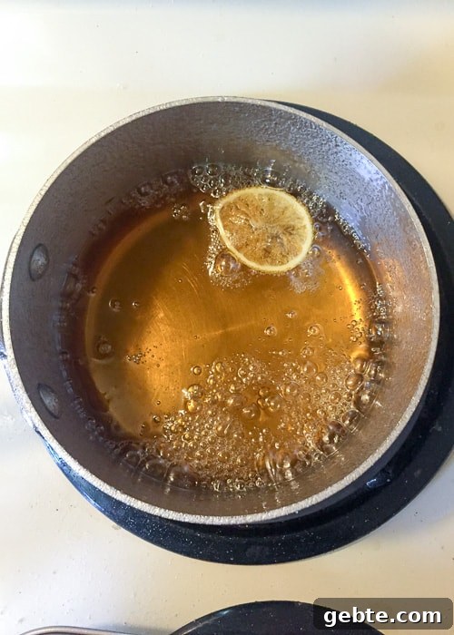 a pot of water with white sugar and slice of lemon