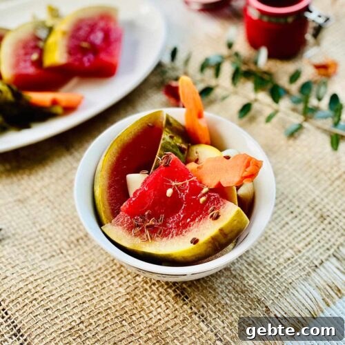 Pickled watermelon quarter slices with pickled carrot in a white serving dish
