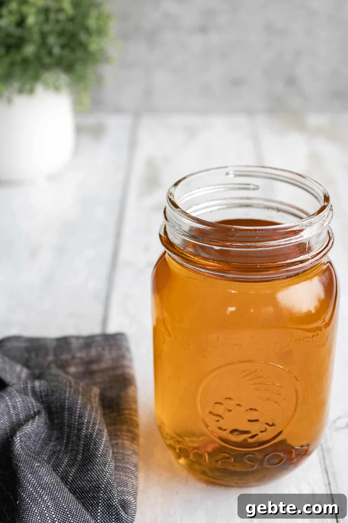 A jar of vanilla syrup on wood.