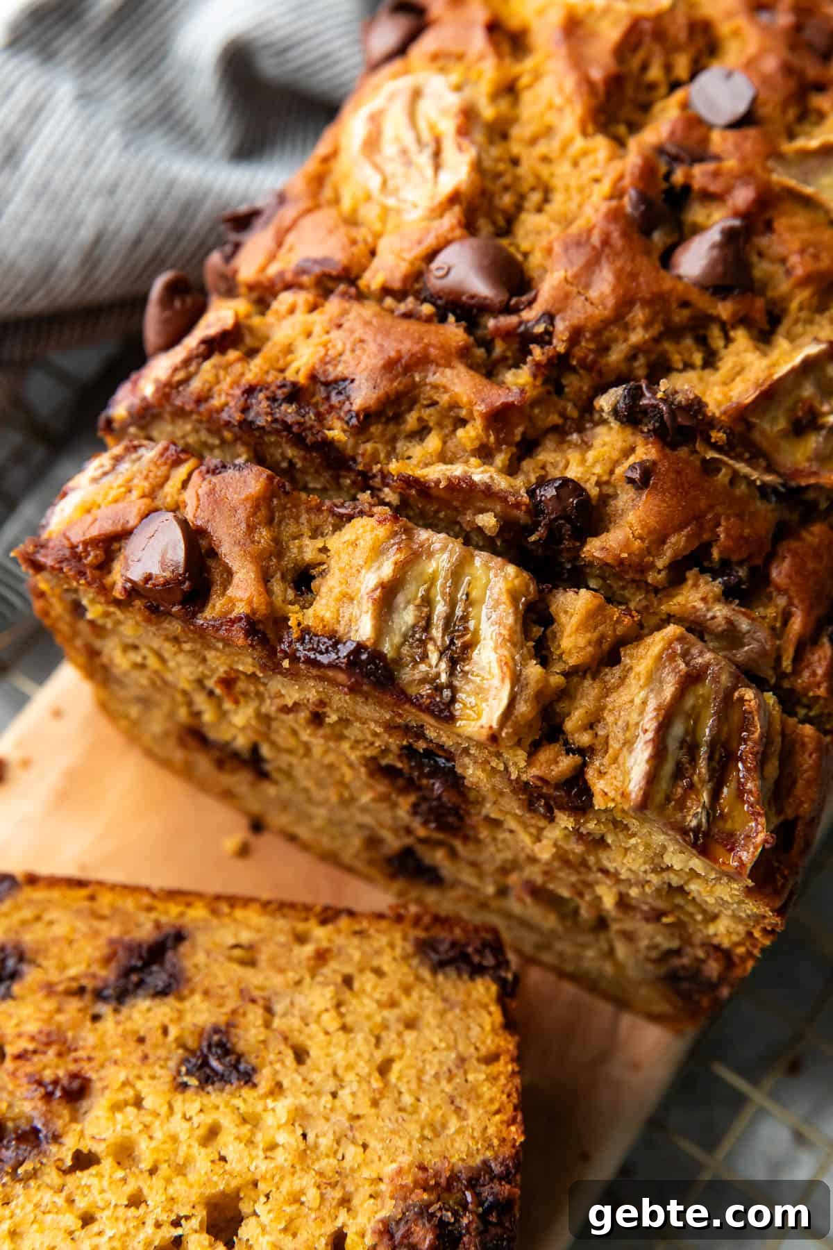 Loaf of pumpkin chocolate chip banana bread cooling on a rack