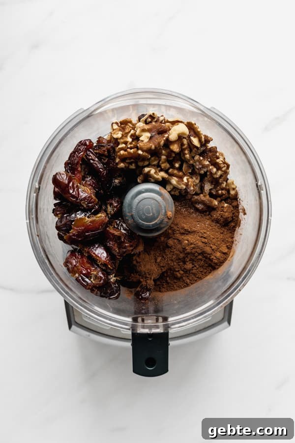 a food processor with dates walnuts and cocoa