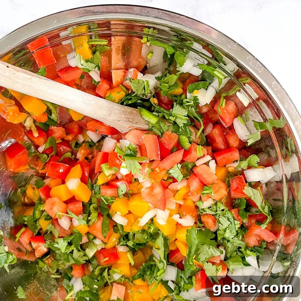7 Most Popular Salsas and How to Use Them 3 The ingredients for mango pico de gallo are stirred in a silver bowl.