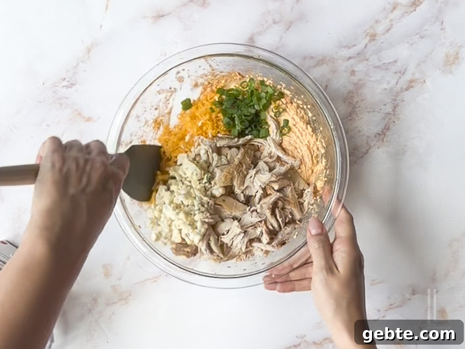 hand-stirring chicken, blue cheese, cheddar cheese, and green onions into cream cheese mixture.
