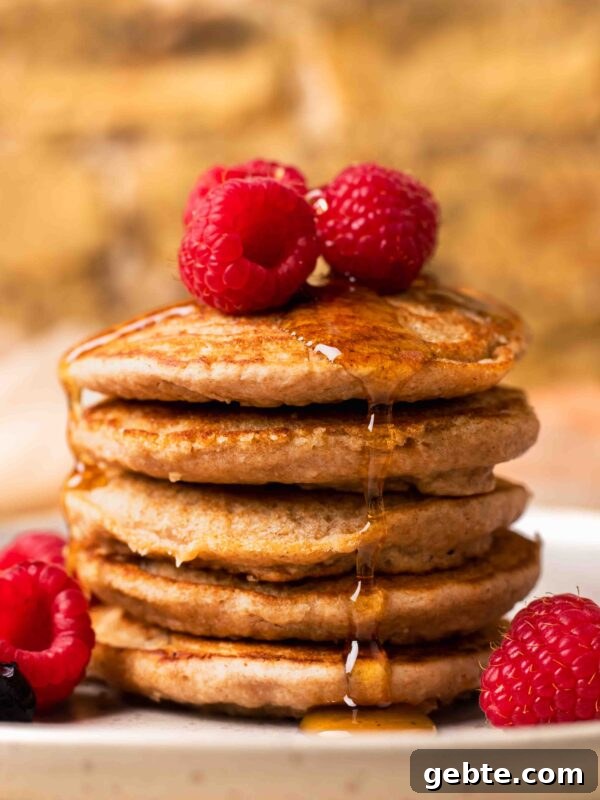 Fluffy Oat Flour Pancakes: Light, Tender Morning Stack 15 An up-close side shot of a small stack of spelt pancakes with raspberries and maple syrup.