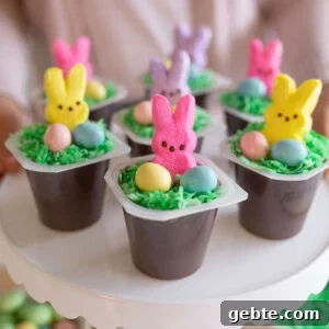 Easter bunny pudding cups displayed on a white cake stand.