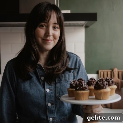 Graham Cracker Crust Pumpkin Pie Recipe for Autumn Celebrations 12 Ella from Alpine Ella is holding a cake stand with cupcakes on it.