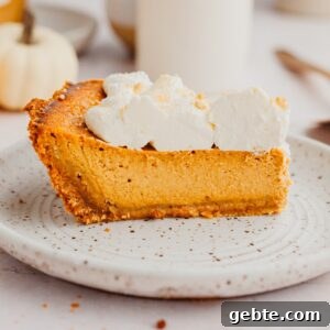 Graham Cracker Crust Pumpkin Pie Recipe for Autumn Celebrations 13 A slice of pumpkin pie topped with whipped cream.