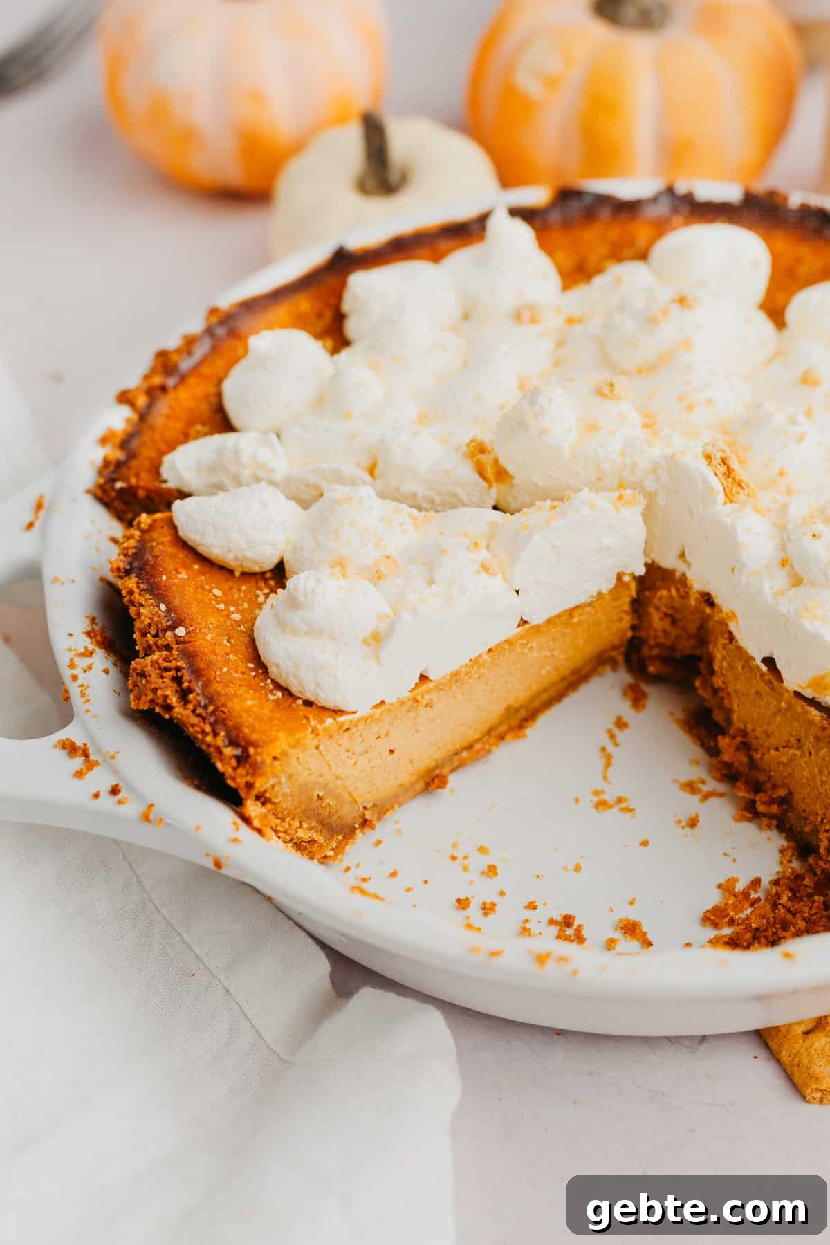 Graham Cracker Crust Pumpkin Pie Recipe for Autumn Celebrations 6 A pumpkin pie with graham cracker crust and topped with whipped cream.