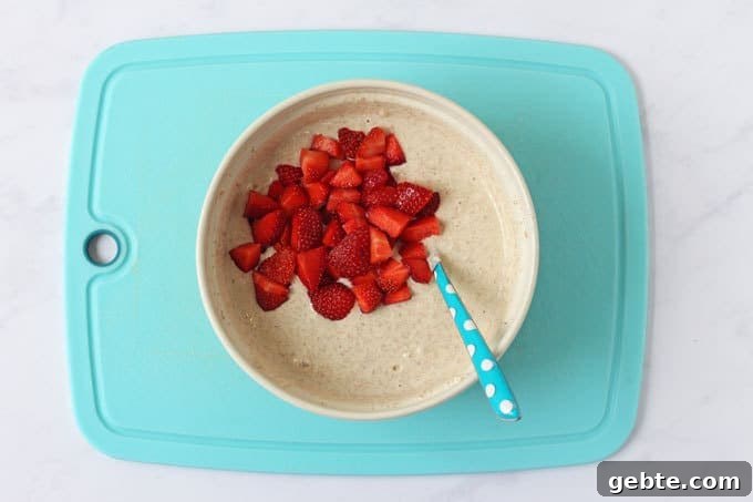 Bowl with pancake mixture and chopped strawberries