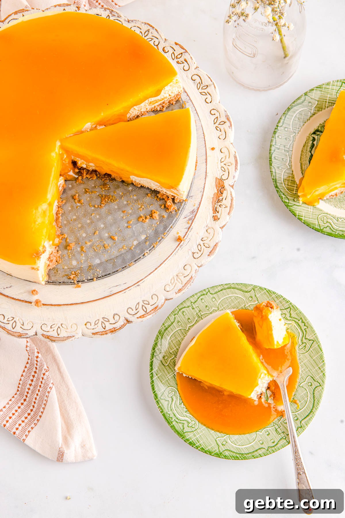Creamy Peach Cheesecake Recipe with Fresh Peach Topping 2 The fnished cheesecake on a pedestal and slices on plates.