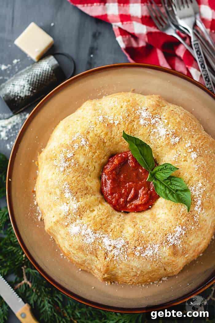 Neapolitan Sausage Meatball Rice Timbale (Sartù di Riso alla Napoletana) 3 An overhead shot of sartu bundt dish with tomato sauce and basil leaves in the middle on a dark background with red towel.