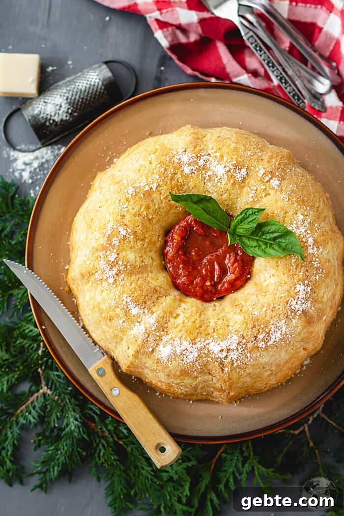 Neapolitan Sausage Meatball Rice Timbale (Sartù di Riso alla Napoletana) 7 Timbale flat lay shot looking festive surrounded with evergreen twigs and red towell. Also in the photo: a knife and cheese grater.