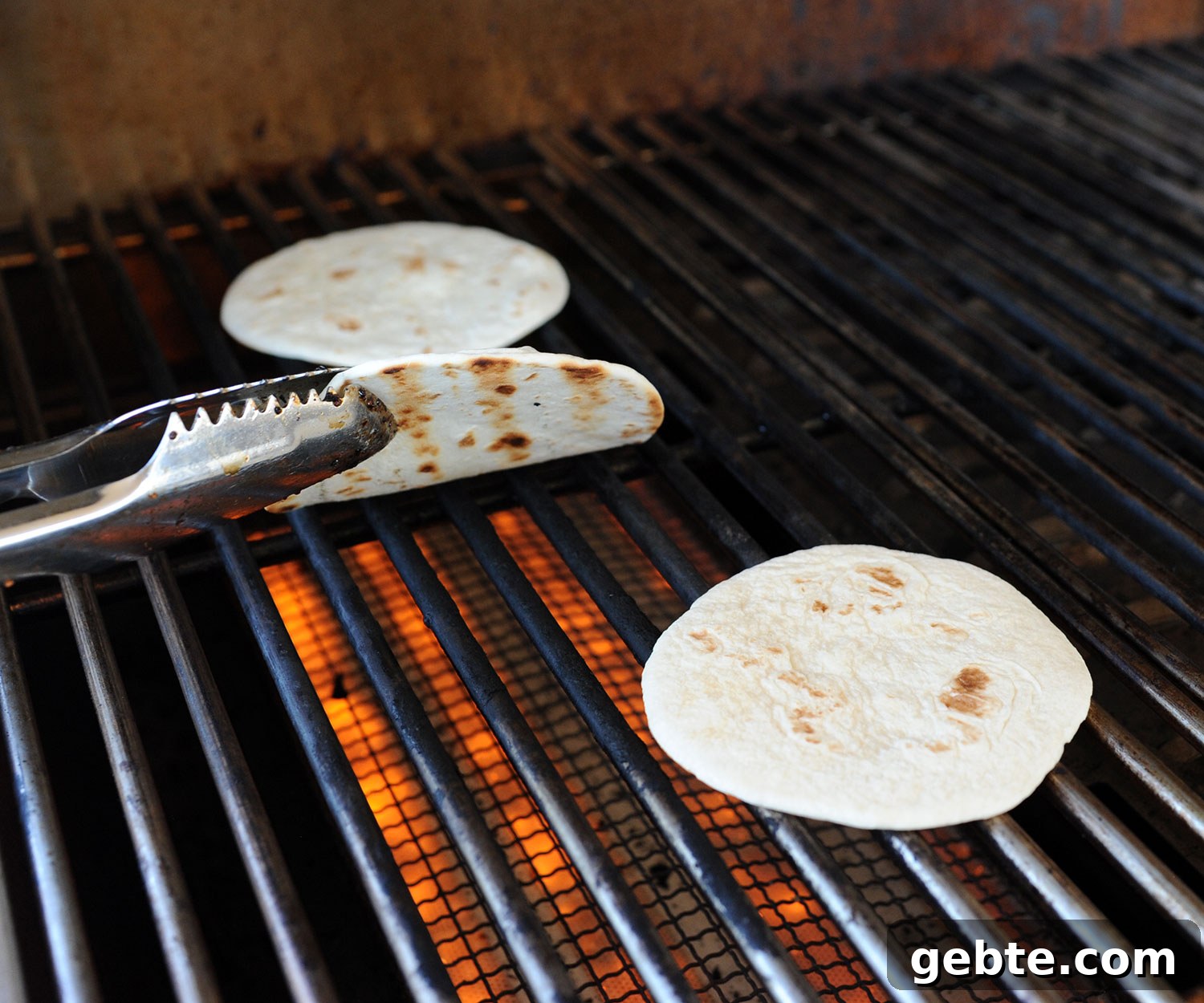 Grilled Skirt Steak Tacos with Charred Lime and Cilantro 8 tongs lifting grilled tortilla