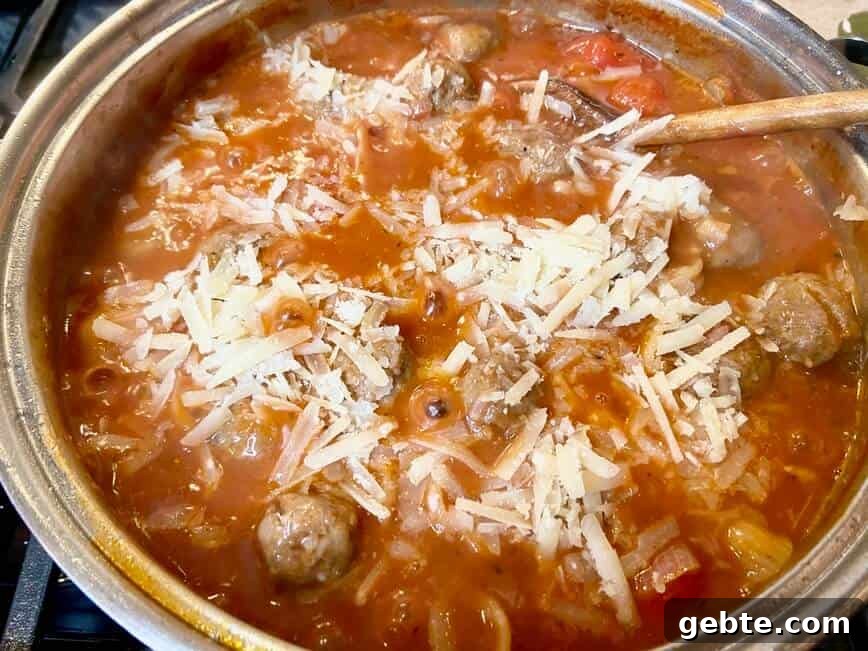 One-Pot Sausage and Meatball Pasta Skillet 11 Adding meatballs and cheese to the pot.