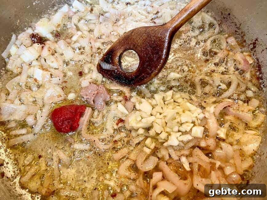 One-Pot Sausage and Meatball Pasta Skillet 9 Sauteing onion, garlic, tomato paste, anchovy paste, and oregano.