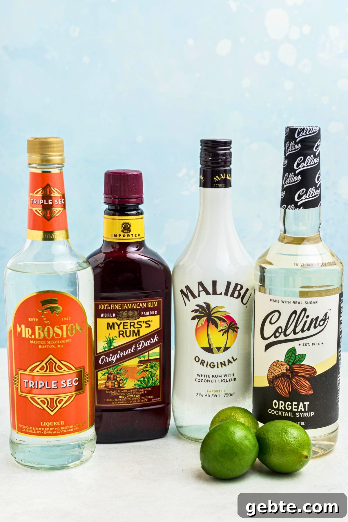 How to Make a Classic Mai Tai Cocktail at Home 3 Light rum, dark rum, Orgeat and Triple sec in bottles, with a few limes on the table.