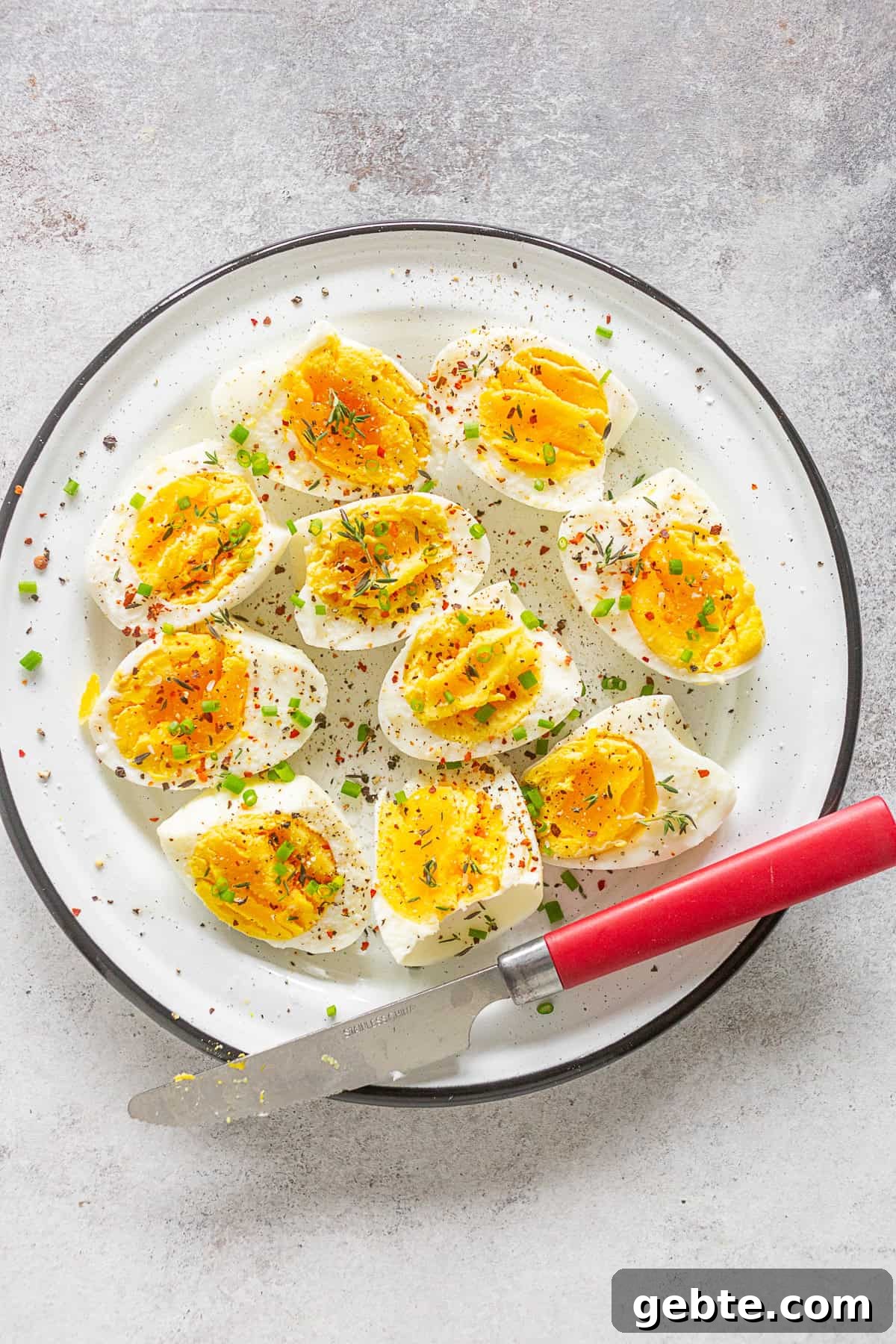 Instant Pot Hard Boiled Eggs on a plate sprinkled with fresh herbs and salt.