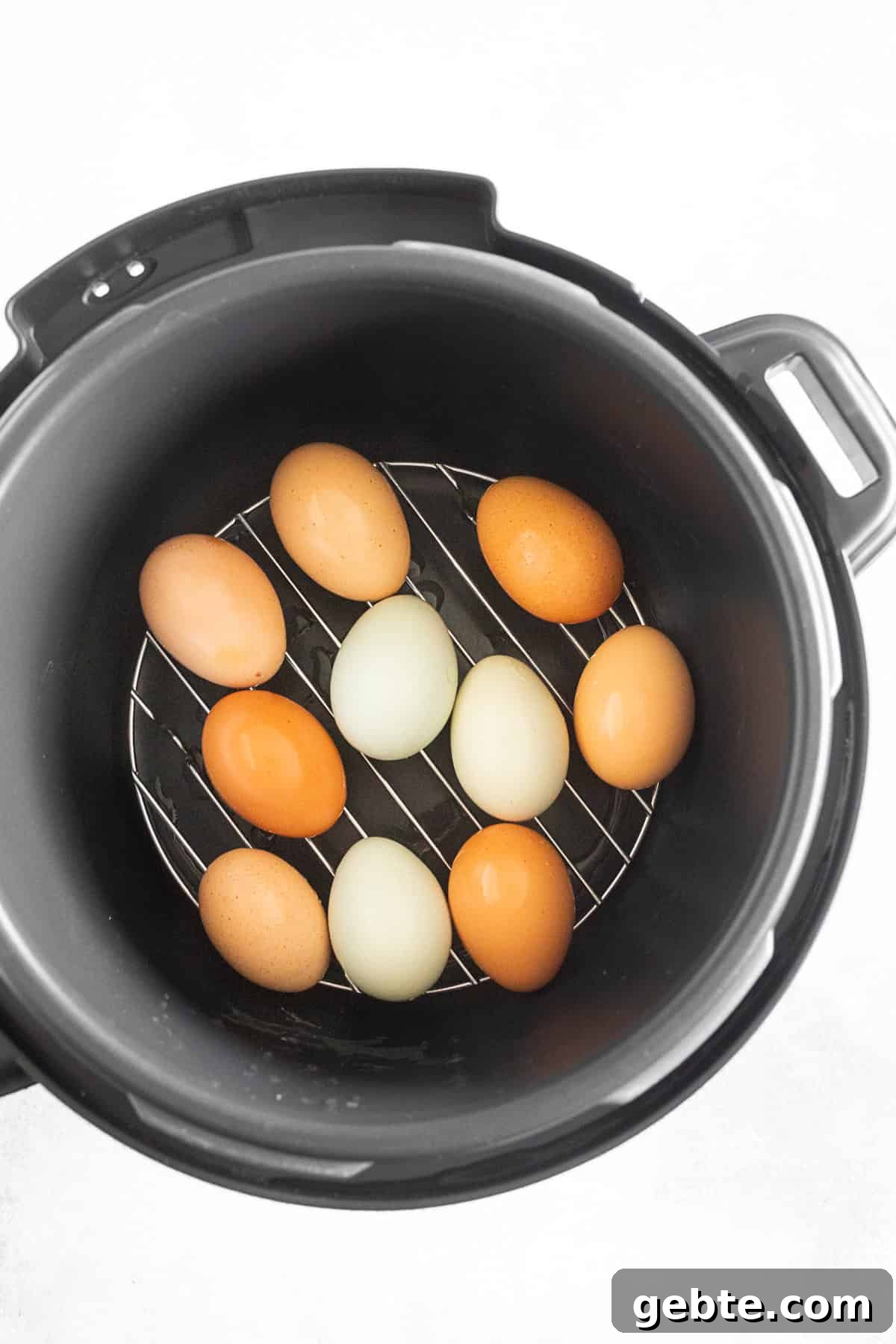 Eggs sitting inside a pressure cooker.