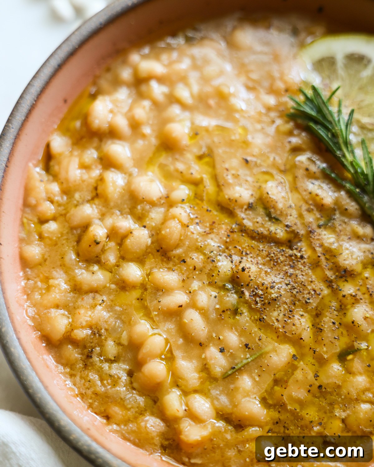 Creamy Instant Pot White Beans with Lemon and Rosemary 9 A close-up shot of the instant pot white beans in a bowl.
