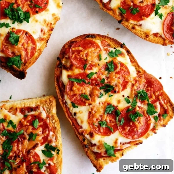 Four slices of pepperoni French bread pizza topped with melted cheese and chopped parsley on a white surface.