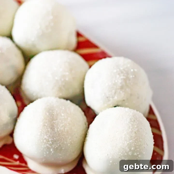 angled picture of sparkling chocolate cookie truffles sitting on a red and white striped tray