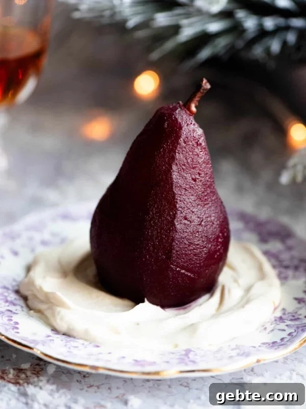 A red wine poached pear sitting on a bed of Amaretto whipped cream on a small plate, the background is Christmassy.