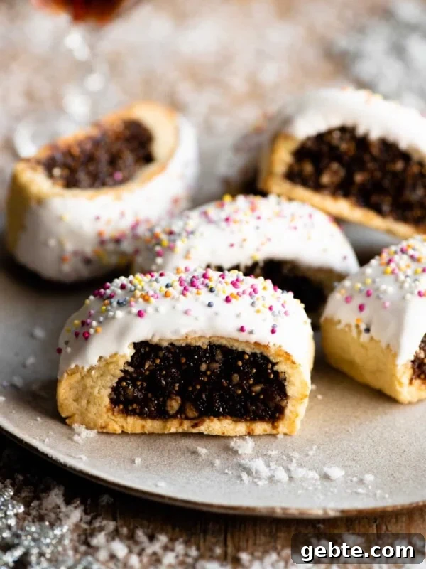 Five Cuccidati cookies on a plate with fake white snow scattered around.