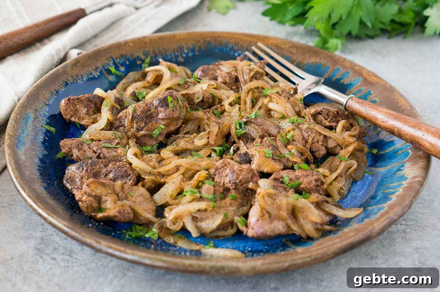 livers and onions on a blue plate