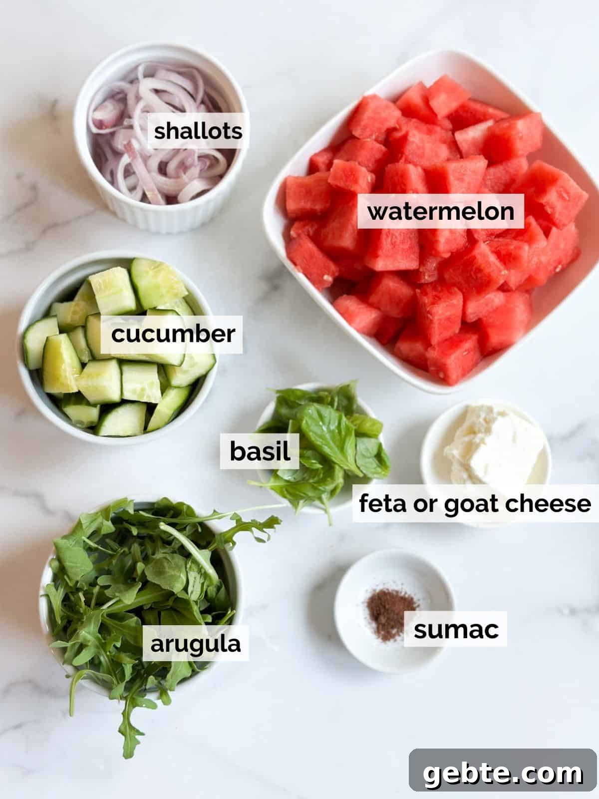 Ingredients for watermelon basil salad on a marble table.
