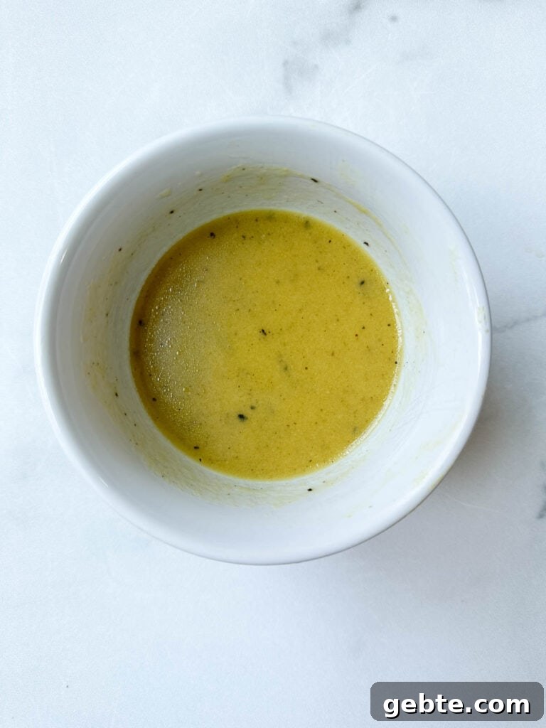 Vinaigrette in a white bowl whisked together.