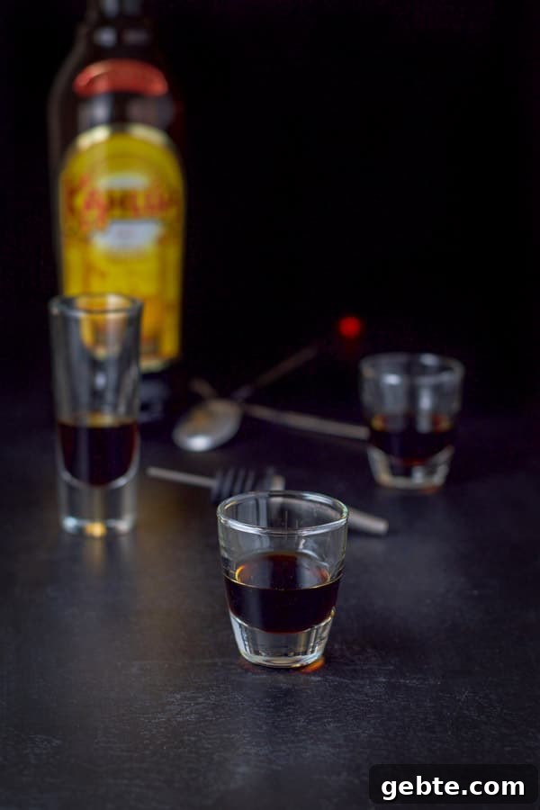 Kahlua poured with the bottle, pourer and spoons in the background