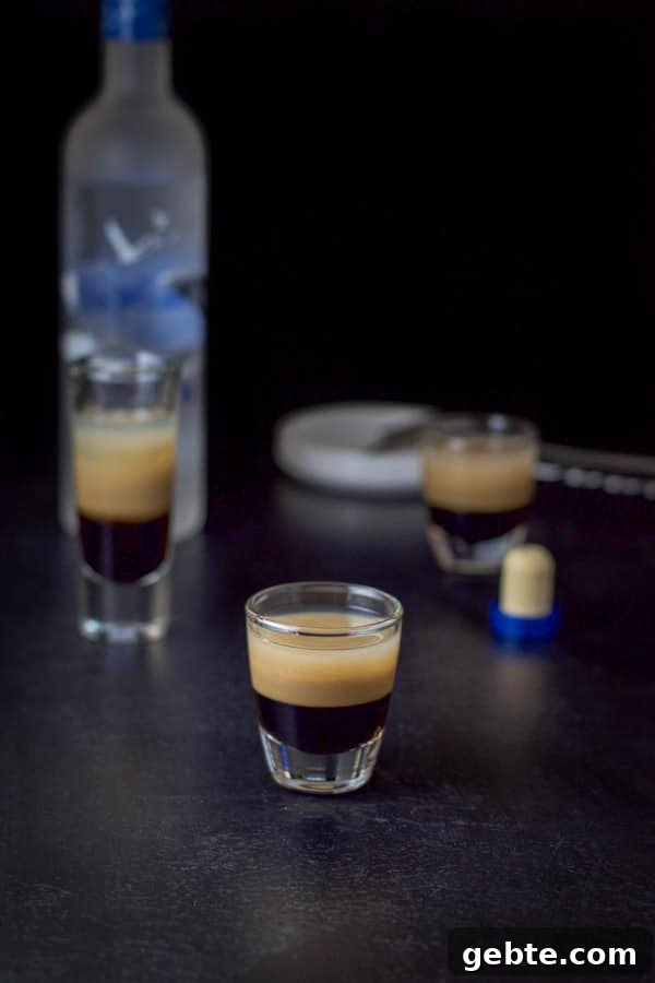 vodka layered in the three glasses with the bottle in the background