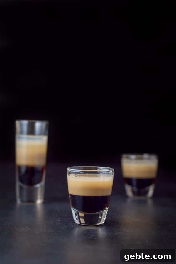 vertical view of the short glass filled with the peppermint shot. The other two glasses are behind it