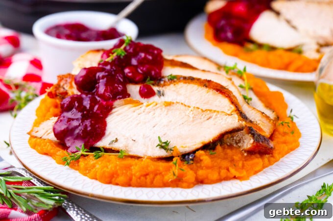 Sliced instant pot turkey breast served with cranberry sauce and mashed sweet potatoes.