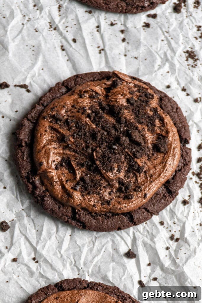 Copycat Crumbl Dirt Cake Cookie Recipe — Soft Chocolate Cake Cookies 3 Close up of a dirt cake crumbl cookie copycat recipe on parchment paper.