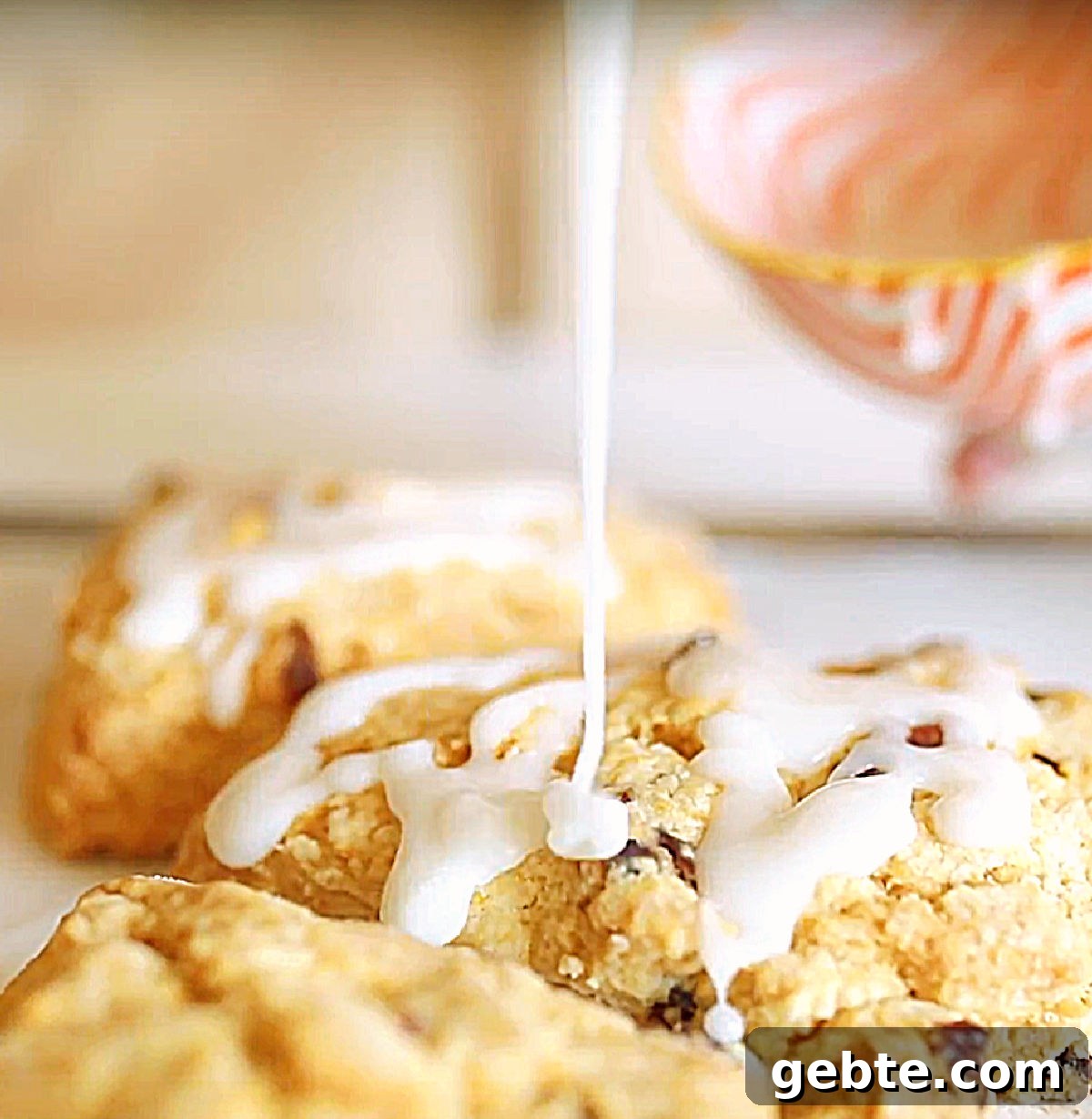 Glazing baked scones from an orange white bowl.