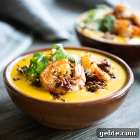 two bowls of chorizo shrimp kabocha squash soup on a grey wooden table