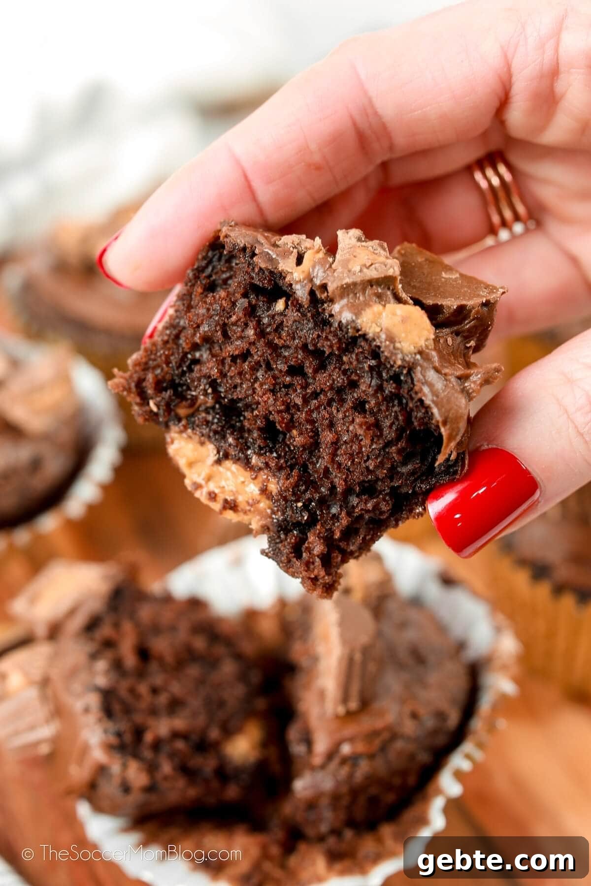 Reese’s Cupcake Recipe: Chocolate Cupcakes Stuffed with Reese’s Cups 5 holding half of a cupcake with a Reese's peanut butter cup inside