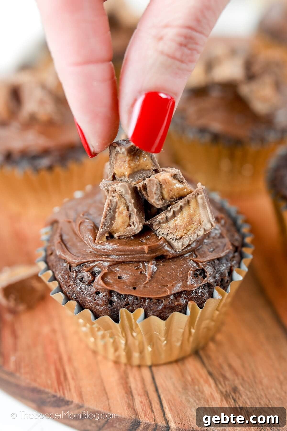 Reese’s Cupcake Recipe: Chocolate Cupcakes Stuffed with Reese’s Cups 7 decorating a chocolate peanut butter cupcake with Reese's cups