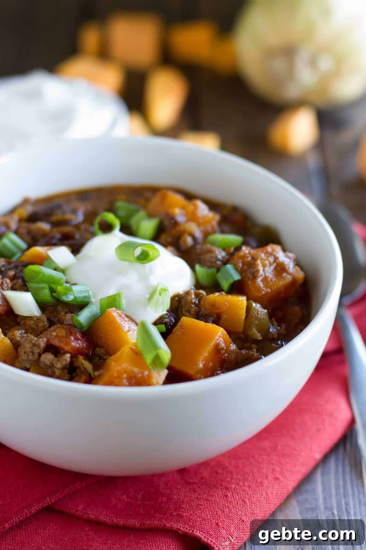Butternut squash, black beans, and ground beef star in this flavor packed Butternut Squash Chili with Beef. Bowl of butternut squash chili with ground beef topped with sour cream.