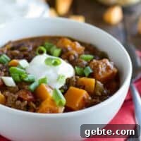 Hearty Beef and Butternut Squash Chili Recipe 2 Bowl of butternut squash chili with ground beef topped with sour cream.