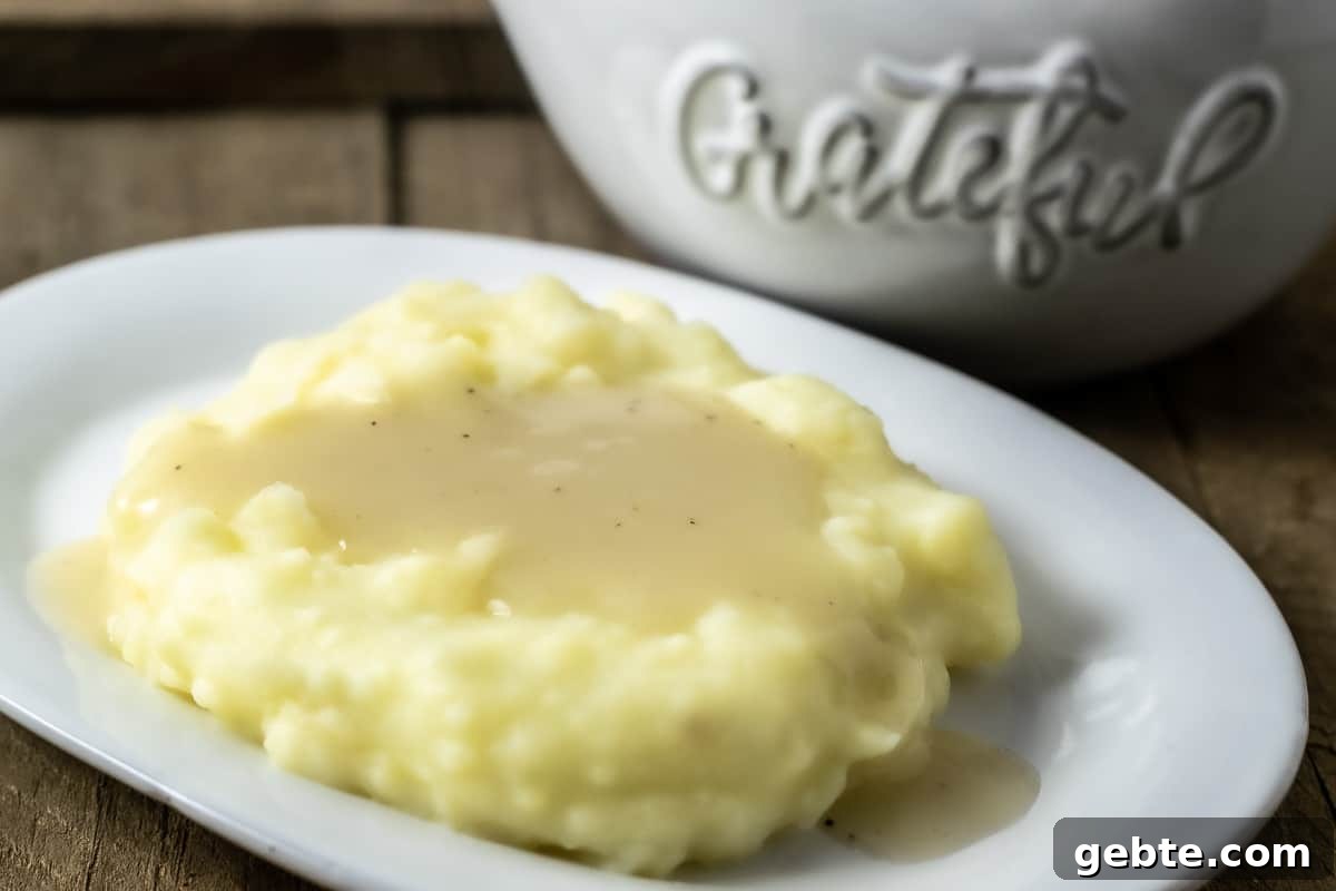 Simple 3-Ingredient Chicken Gravy Made from Scratch 5 easy chicken gravy from scratch poured over mashed potatoes on a plate